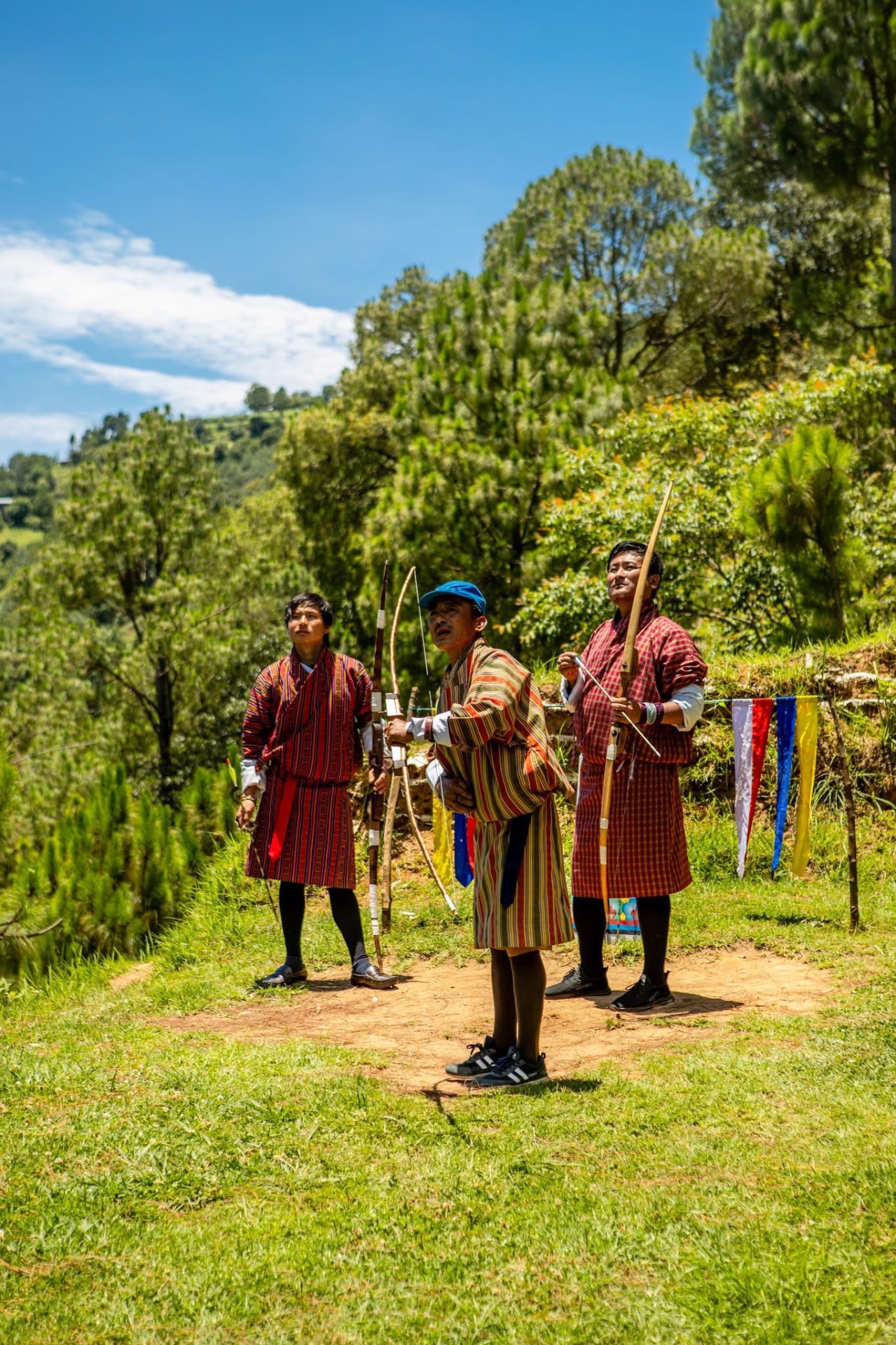 Bhutanese archers in traditional gho at a village archery ground
