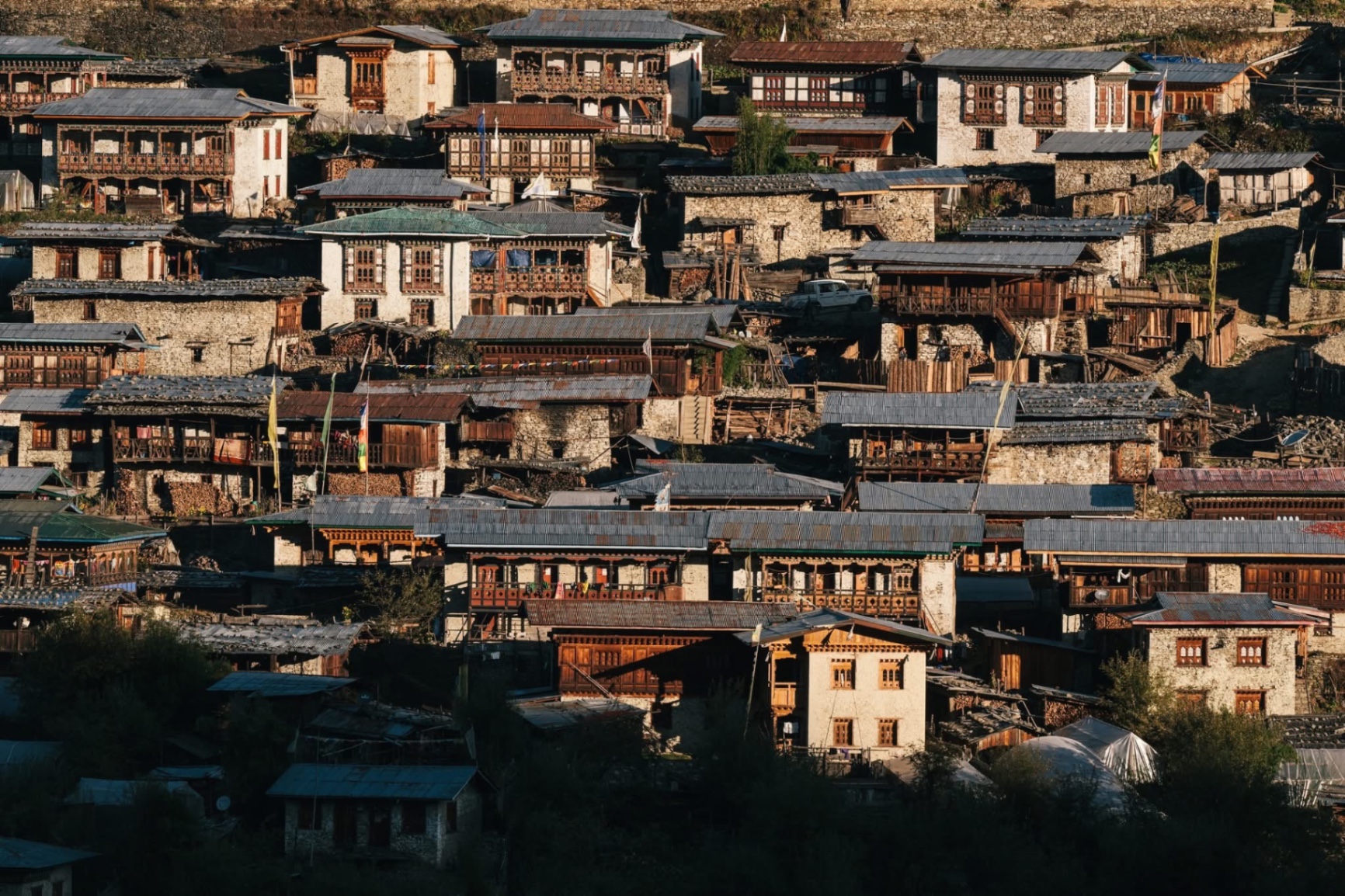 Traditional Bhutanese village houses on a hillside in late afternoon light