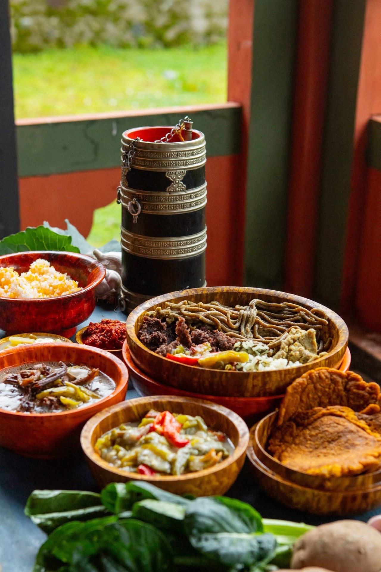Bhutanese dishes including buckwheat noodles, red rice and ema datshi in wooden bowls